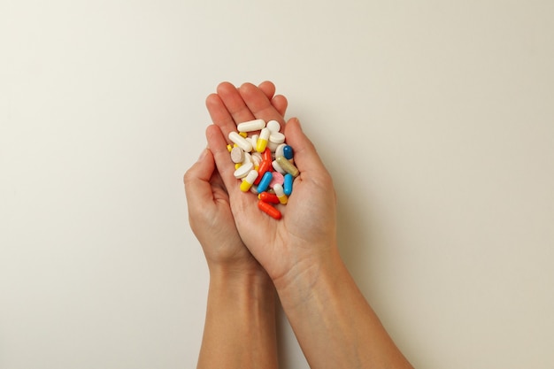 Manos femeninas sostienen diferentes pastillas en blanco