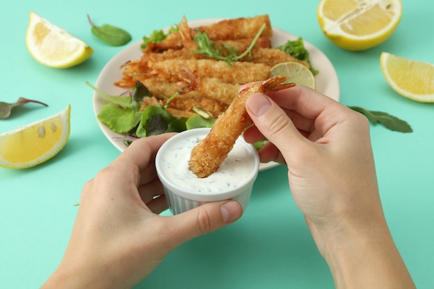 Manos femeninas sostienen fondo de menta de camarones fritos