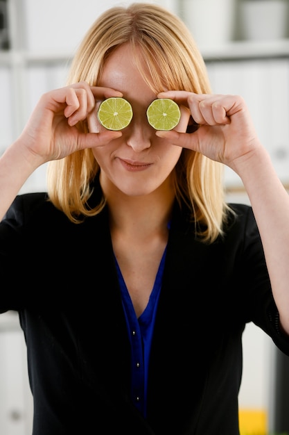 Manos femeninas sostienen una fruta cortada al nivel de los ojos