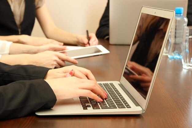 Manos femeninas con tableta digital en el fondo de la oficina