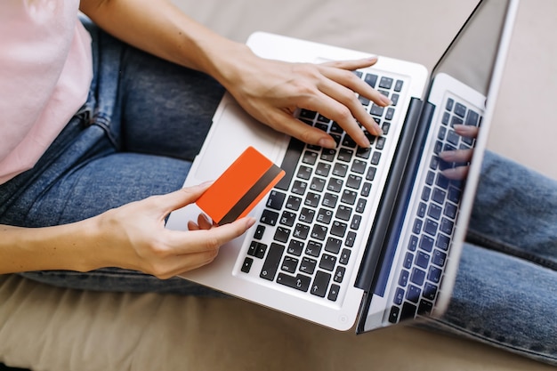 Foto manos femeninas con tarjeta de crédito y usando laptop