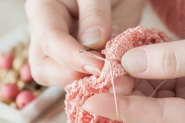 Manos femeninas con tejido rosa