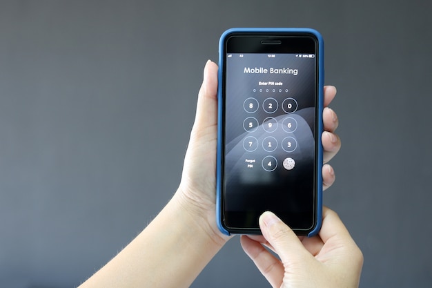 Foto manos femeninas tienen banca móvil en el teléfono inteligente