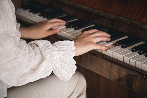 Manos femeninas tocando el viejo piano closeup