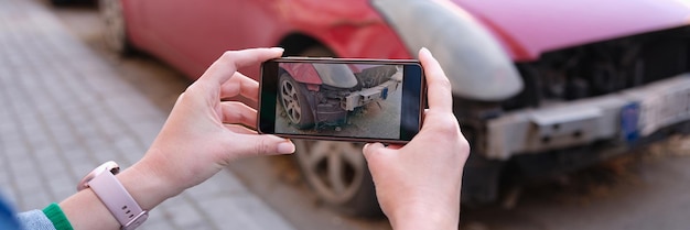 Manos femeninas tomando fotos de daños en el automóvil en el teléfono móvil closeup seguro de automóvil daños en el automóvil