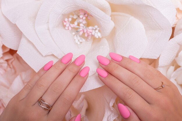 Manos femeninas con uñas de manicura de boda esmalte de gel rosa