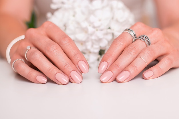 Manos femeninas con uñas de manicura de boda