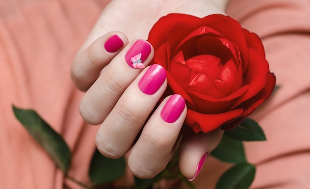 Manos femeninas con uñas rosadas.