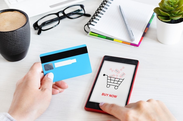 Manos femeninas usando teléfonos inteligentes para compras en línea