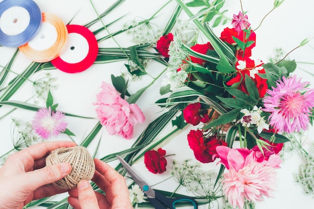 Foto las manos de un florista masculino haciendo una bella composición de flores.