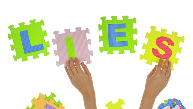 Foto manos formando la palabra mentiras con piezas de un rompecabezas