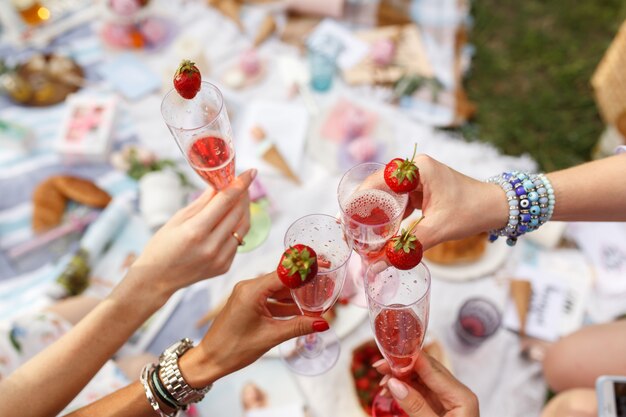 Manos con gafas vítores en día de verano picnic.