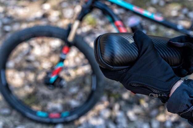 Foto manos en guantes de bicicleta sostienen un conjunto de bicicletas