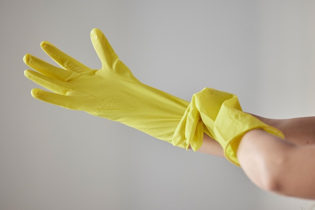 Manos guantes de goma amarillos y mujer de limpieza lista para el servicio de limpieza de trabajadores limpieza de primavera o tareas domésticas en el fondo del estudio Criada higiene seguridad bienestar y uniforme de mantenimiento de bacterias