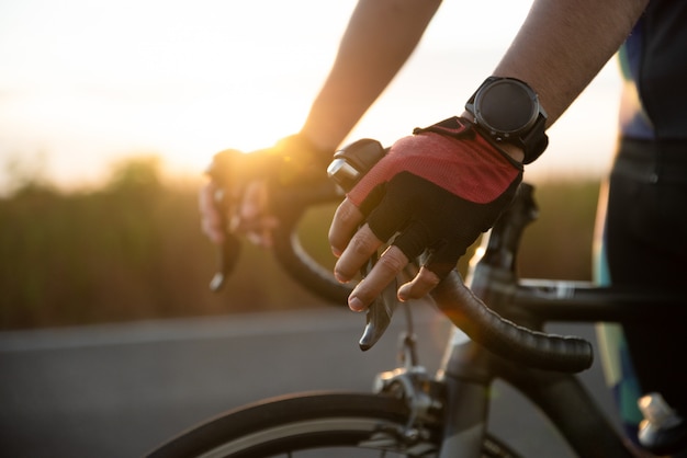 Manos en guantes con manillar de bicicleta de carretera