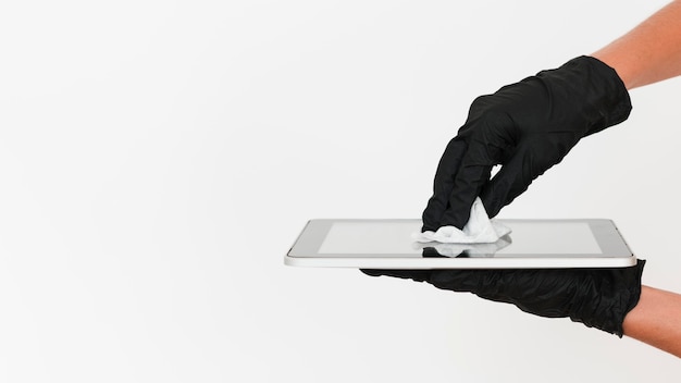 Manos con guantes quirúrgicos desinfectante tableta con espacio de copia