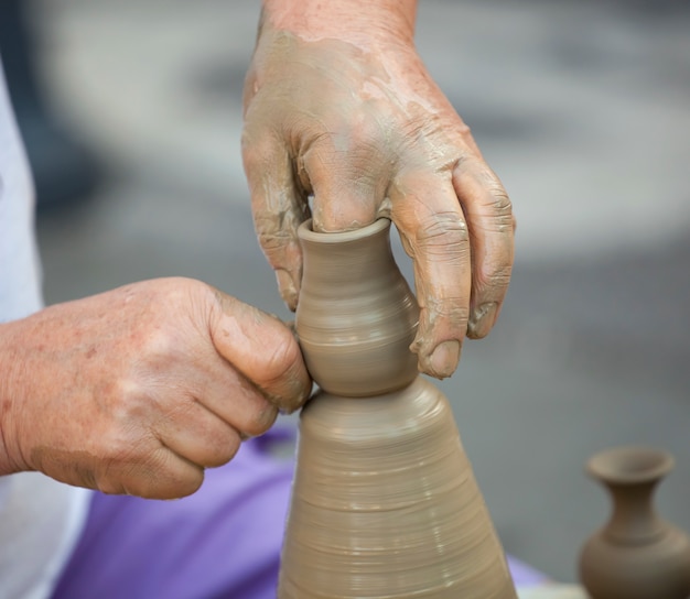 Manos haciendo cerámica en una rueda