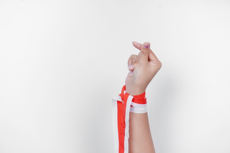 Foto manos haciendo gestos de amor con cinta roja y blanca de indonesia concepto del día de la independencia de indonesia