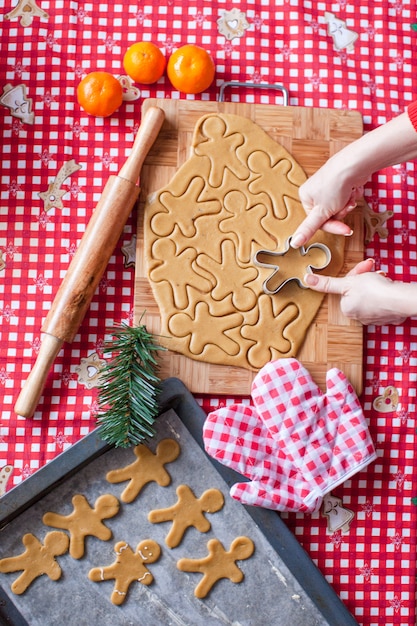 Manos haciendo masa de hombre de jengibre de navidad