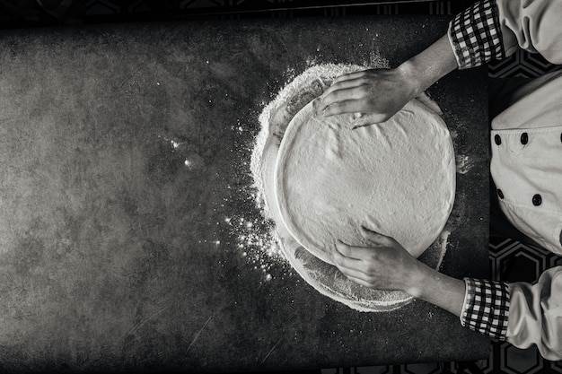 Manos haciendo una masa de pizza con harina