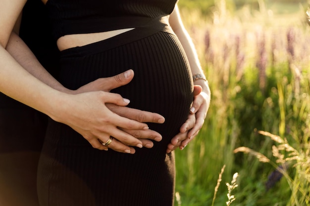 Foto las manos de un hombre abrazan el vientre de una mujer embarazada foto recortada embarazo y concepto de familia feliz