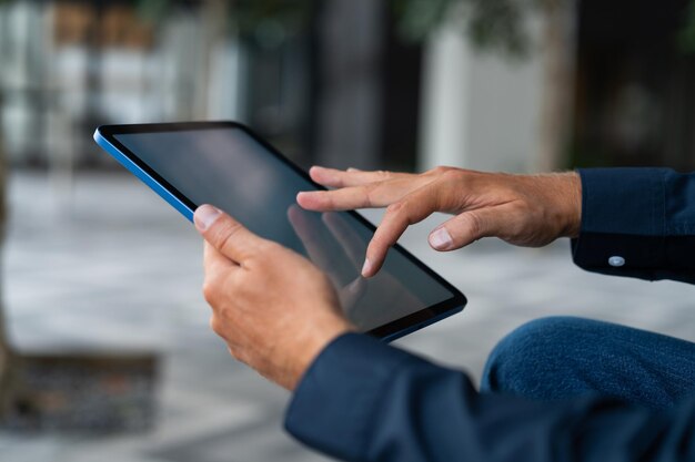 Manos de hombre deslizando sobre la pantalla de la tableta