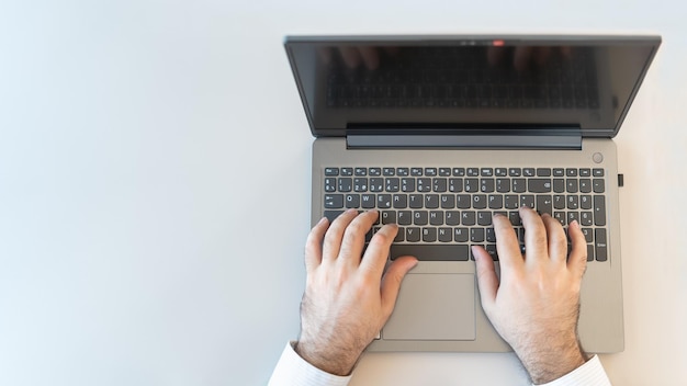 Manos de hombre escribiendo una foto de computadora portátil con espacio de copia