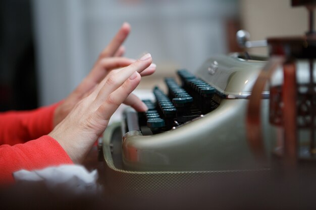 Manos de un hombre escribiendo en máquina de escribir