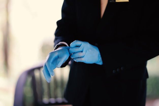 Las manos de un hombre con guantes azules preparándose para un evento