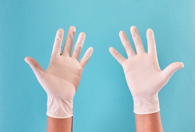 Manos del hombre con guantes de látex que muestran las palmas.