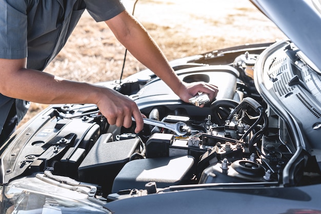 manos de hombre haciendo reparación o mantenimiento a un automóvil