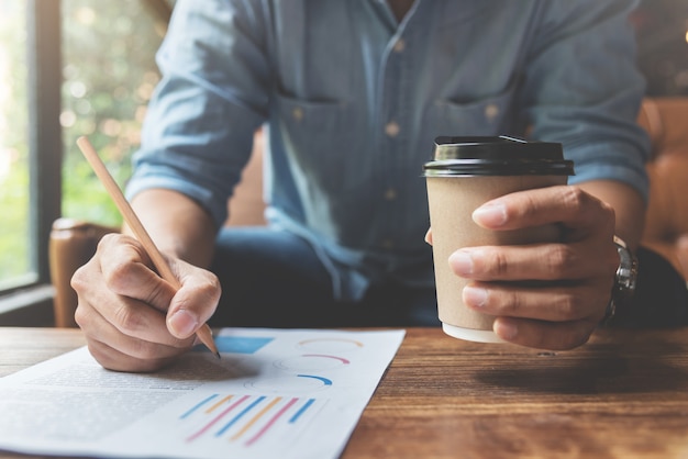 Manos de hombre independiente o de negocios sosteniendo la taza de café