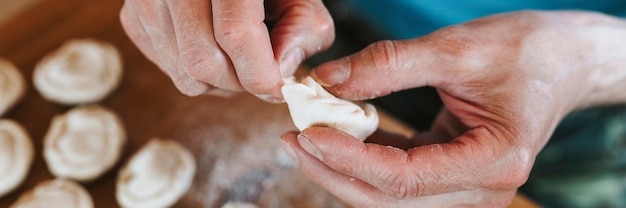 Manos del hombre mayor cocinar y moldear pequeñas albóndigas crudas caseras