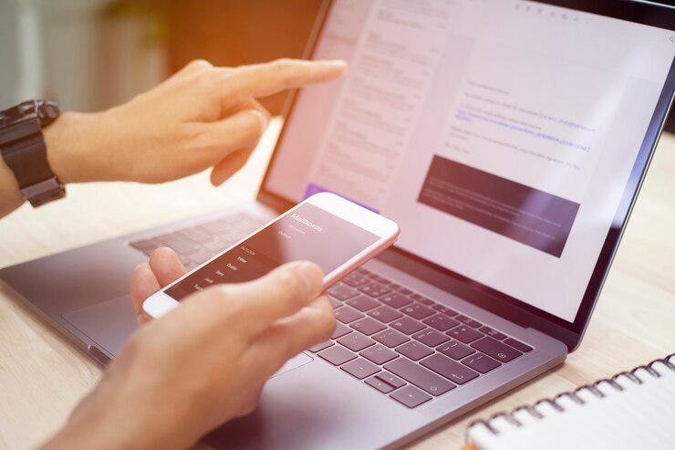 Foto manos de hombre de negocios con teléfono inteligente enviado correo electrónico y usando laptop