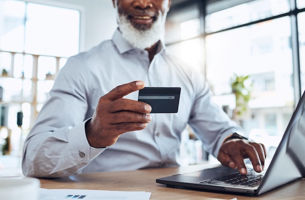 Manos de hombre negro tarjeta de crédito comercial y computadora portátil para finanzas de comercio electrónico o contabilidad en la oficina Computadora de trabajador y pago financiero de presupuesto comercial fintech o banca de economía de inversión