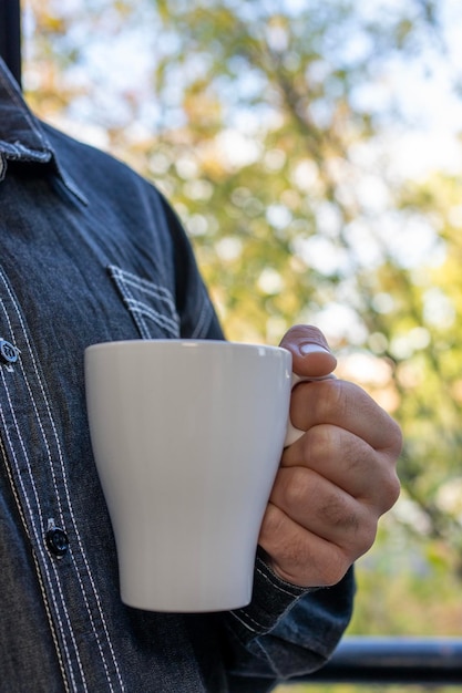 Manos de hombre sosteniendo una taza de café