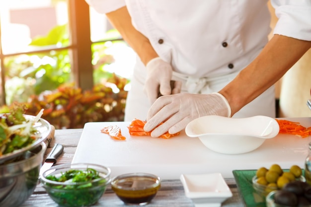 Las manos del hombre tocan el pescado crudo.