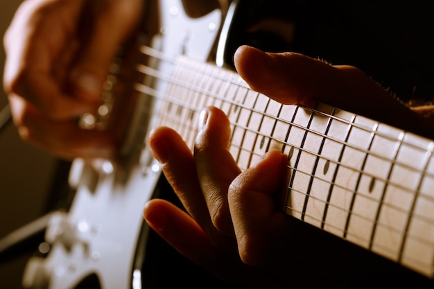 Manos del hombre tocando la guitarra eléctrica