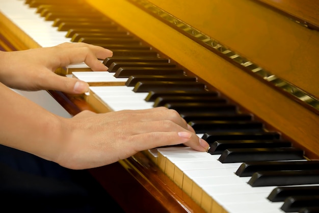 Manos de hombre tocando el piano de cerca