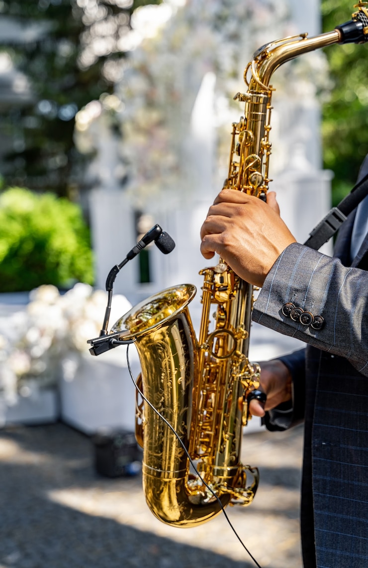Foto manos de hombre tocando el saxofón. vista de cerca de las manos de un saxofonista masculino tocando un saxofón tenor. jazz, música clásica y blues en la boda.