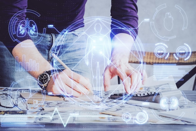 Manos del hombre trabajando con notas de fondo Diagrama de registro de computadora moderna con mnitor virtual