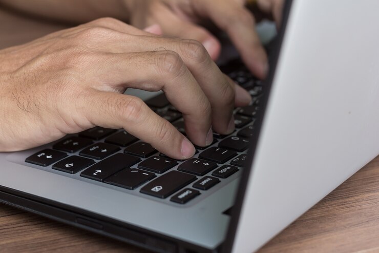 Foto manos del hombre usando la computadora portátil