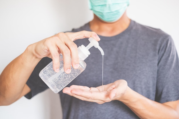 Foto manos de hombre usando dispensador de gel desinfectante para manos