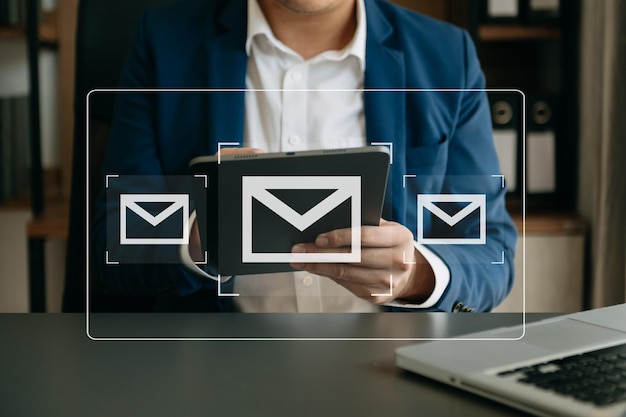 Manos de hombre usando tableta portátil escribiendo en el teclado y navegando por Internet con icono de correo electrónico concepto de marketing por correo electrónico enviar correo electrónico o boletín en línea tecnología de red de Internet de trabajoxA