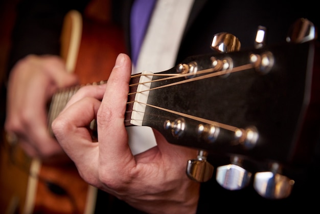 Manos de los hombres con una guitarra.