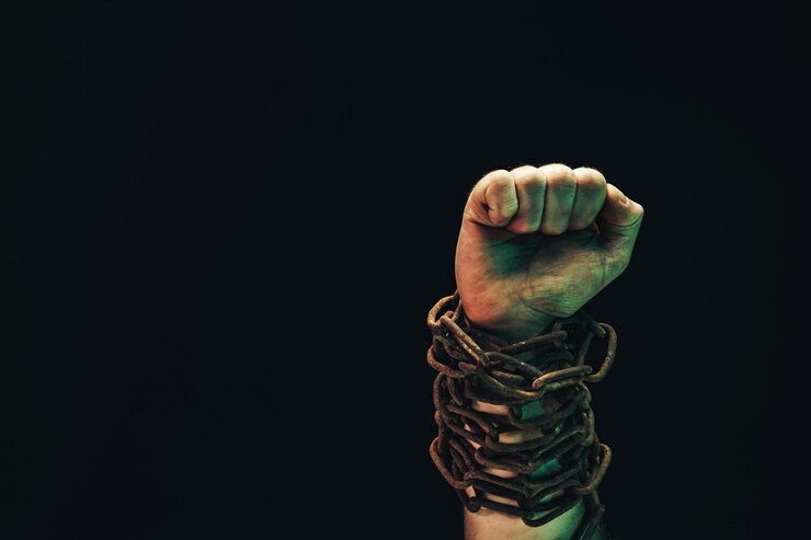 Foto las manos humanas están encadenadas en cadenas aisladas sobre un fondo negro.