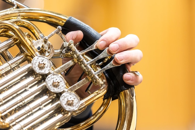 Manos de instrumentos de trompa tocando el trompetista en la orquesta filarmónica