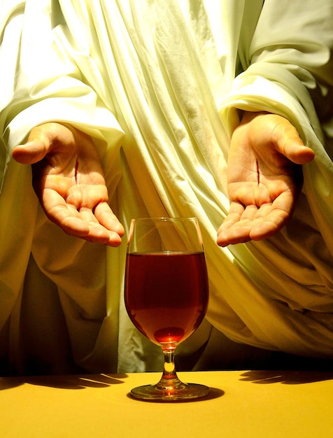 Manos de Jesús y copa de vino