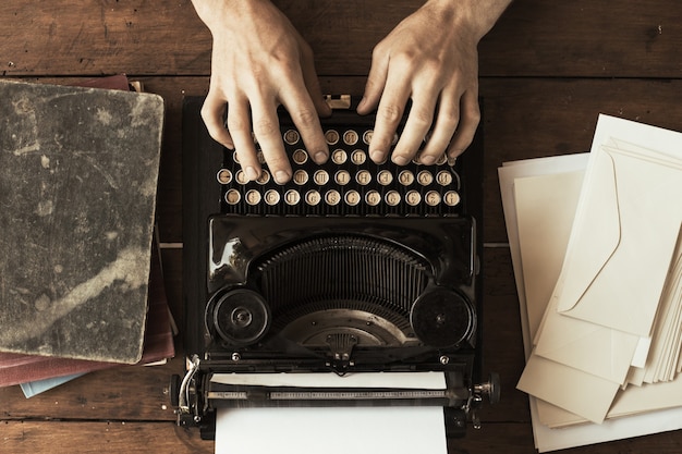 Las manos del joven escribiendo en una antigua máquina de escribir vintage