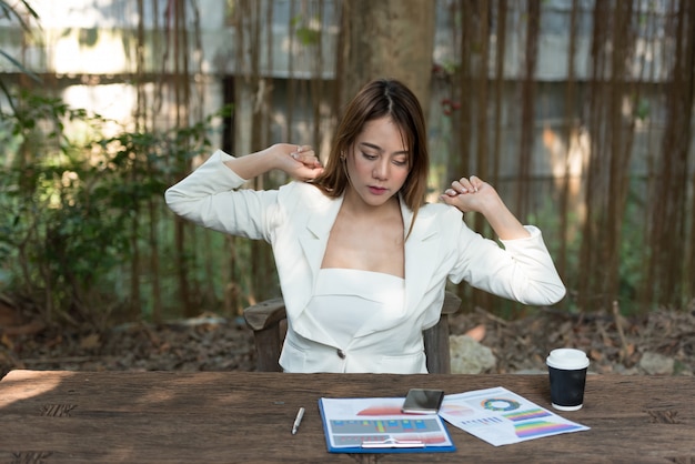 Manos jovenes del estiramiento de la mujer de negocios en el trabajo para relajarse en el parque.